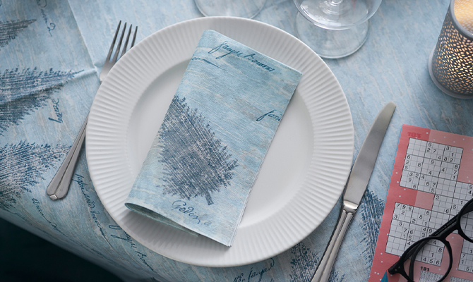Blue folded Christmas napkin on table