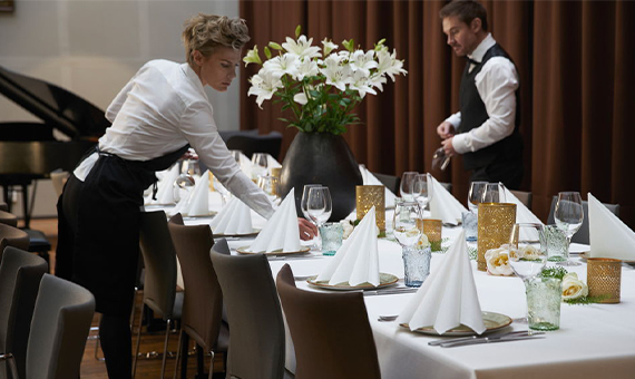 Waiters setting a formal restaurant event table